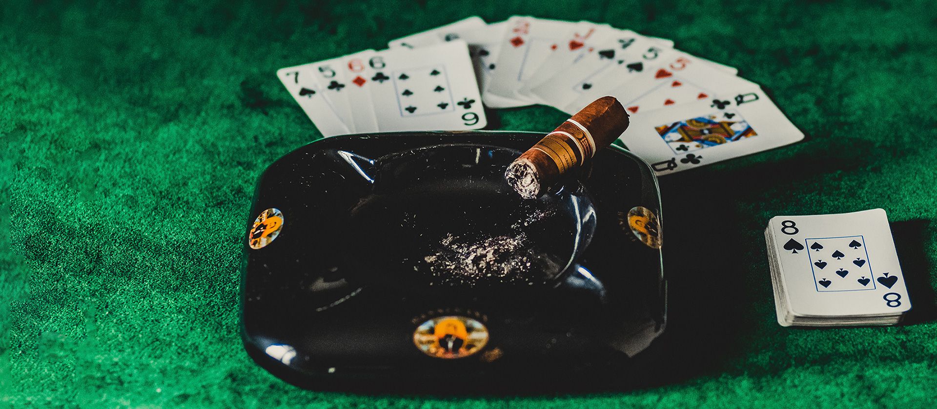 Cigar with cards on the gaming table.